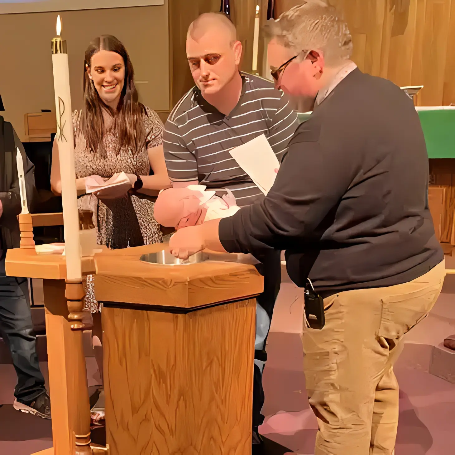 Priest baptizing infant during ceremony