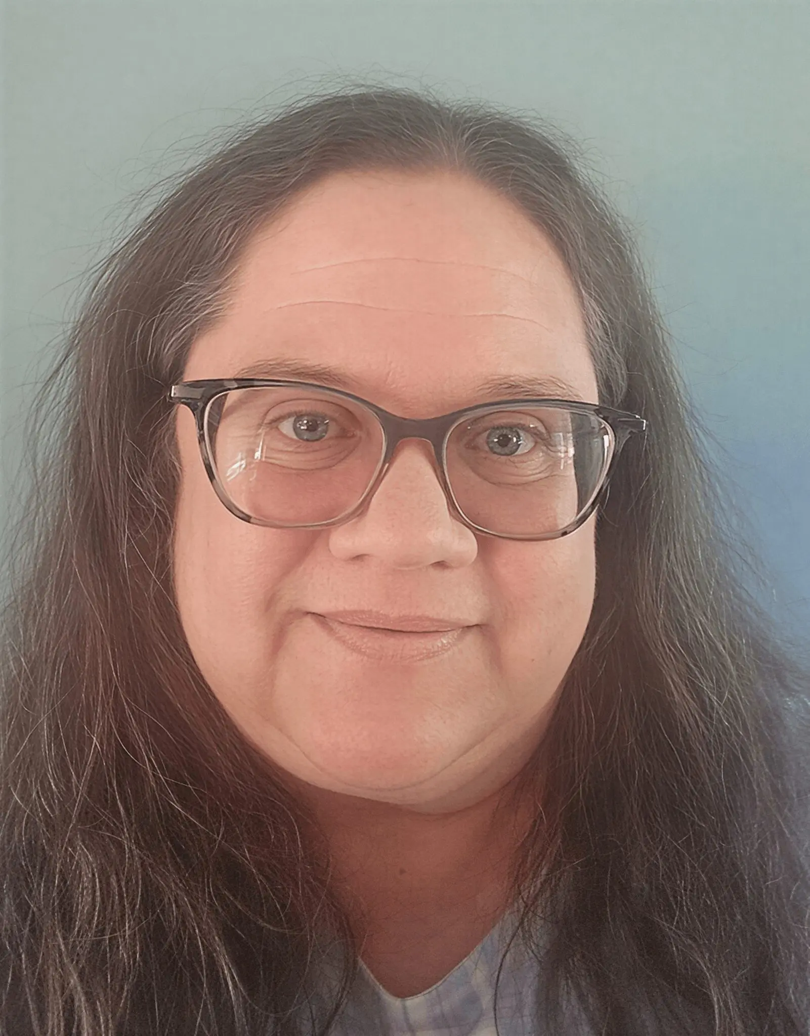 Person with glasses smiling at camera