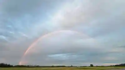 Scenic landscape with rainbow and clouds