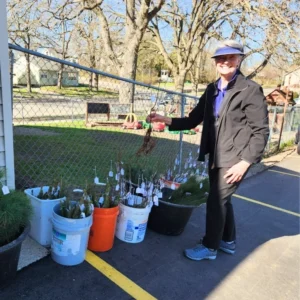 Person with plants in buckets outdoors
