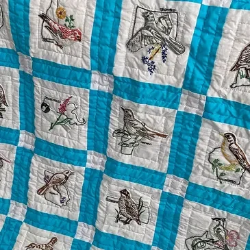 Colorful quilt featuring bird embroidery designs
